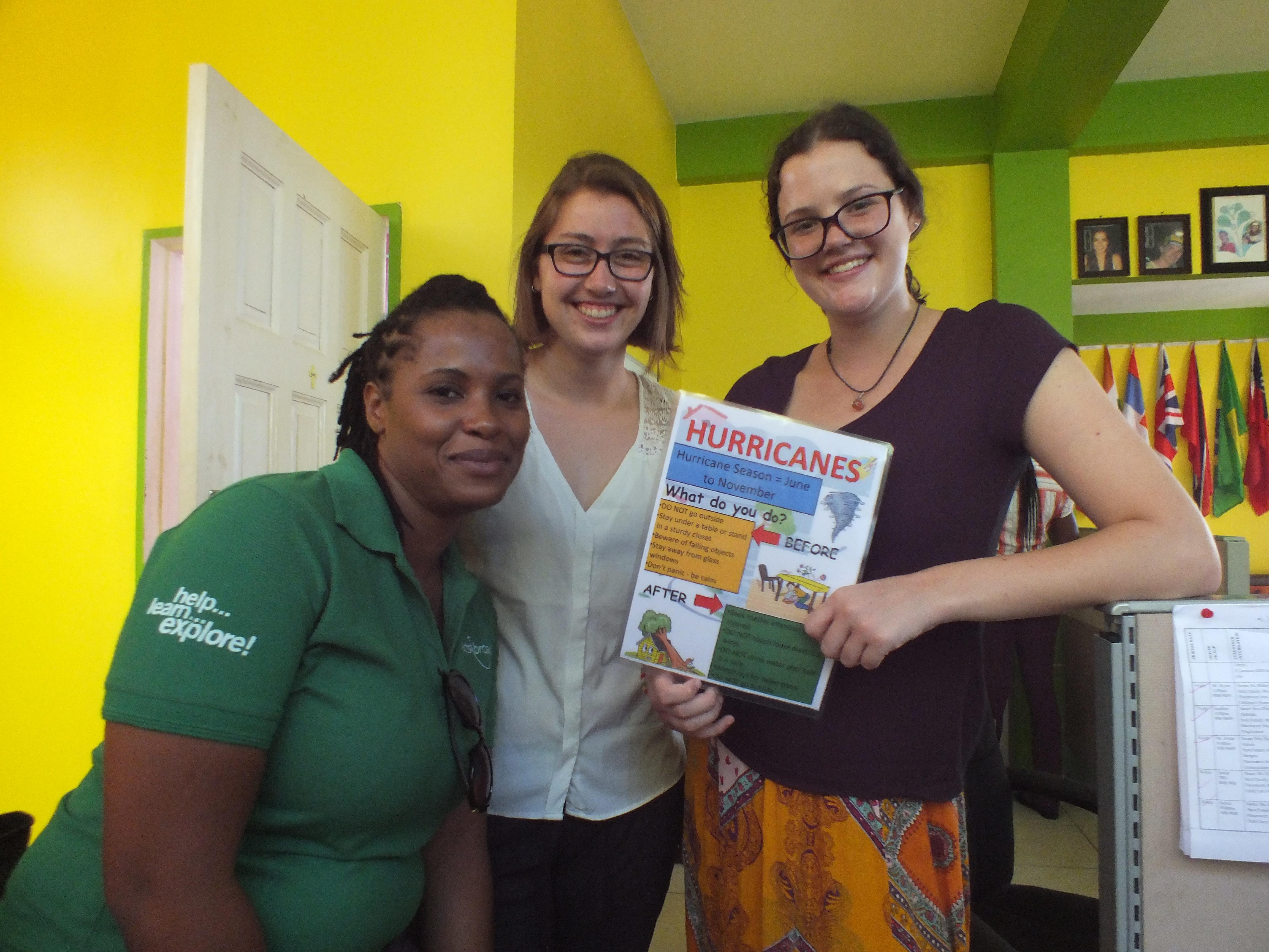 Female Projects Abroad Disaster Managment interns pose with a poster about dealing with hurricanes during Disaster Management work experience in Jamaica. Female International Development interns pose in a day centre holding a poster during their Disaster Management work experience in Jamaica.